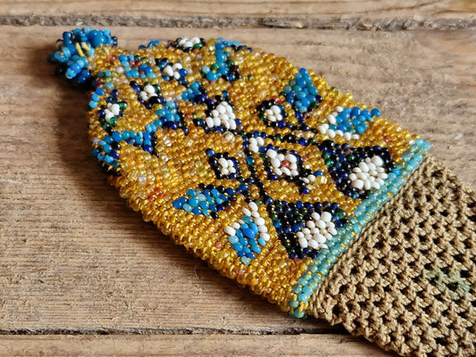 Beaded yellow and blue misers purse on a wooden background