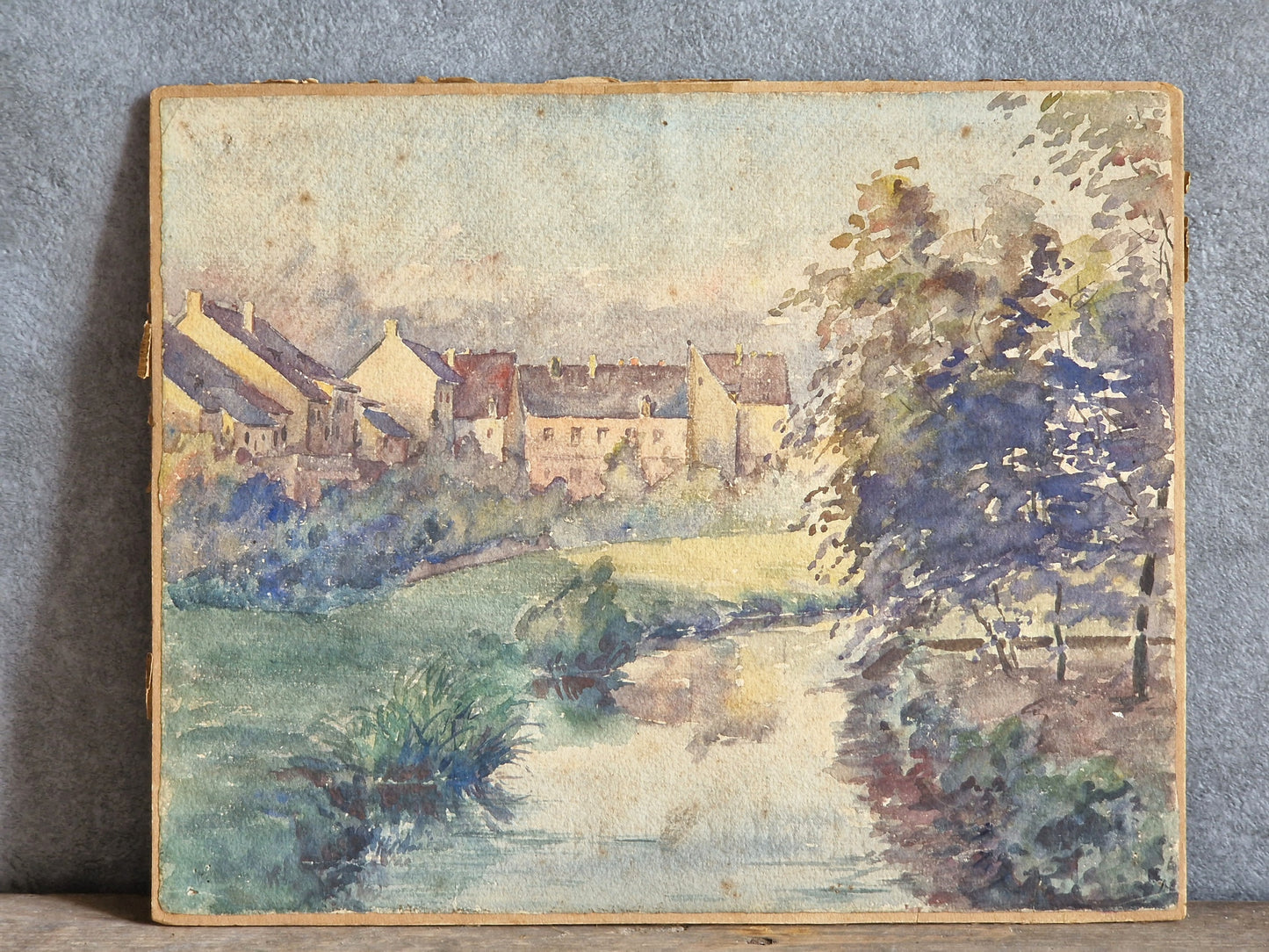 Painting of a village scene with houses and trees on a textured surface