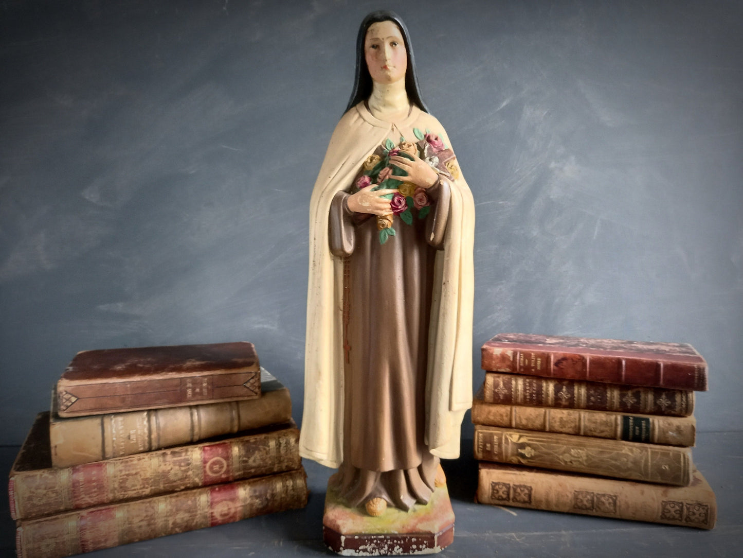 Statue of a religious figure, St. Therese, holding flowers.