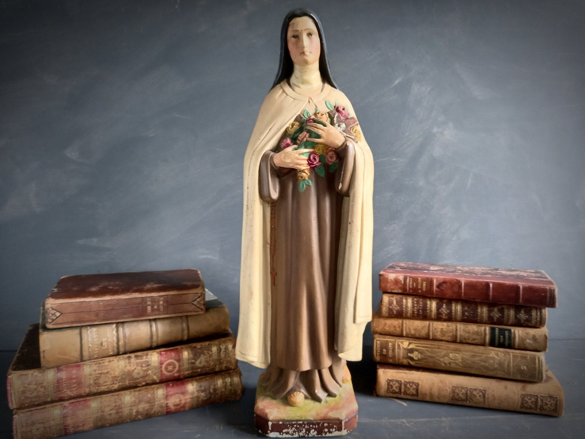 Statue of a religious figure, St. Therese, holding flowers.