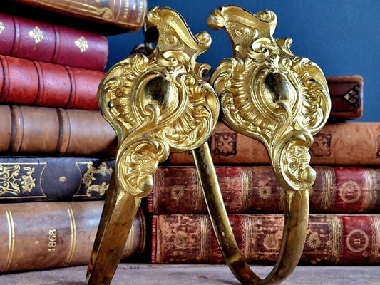 French gilt brass curtain tiebacks. Pair of French rococo style gilt brass tiebacks.