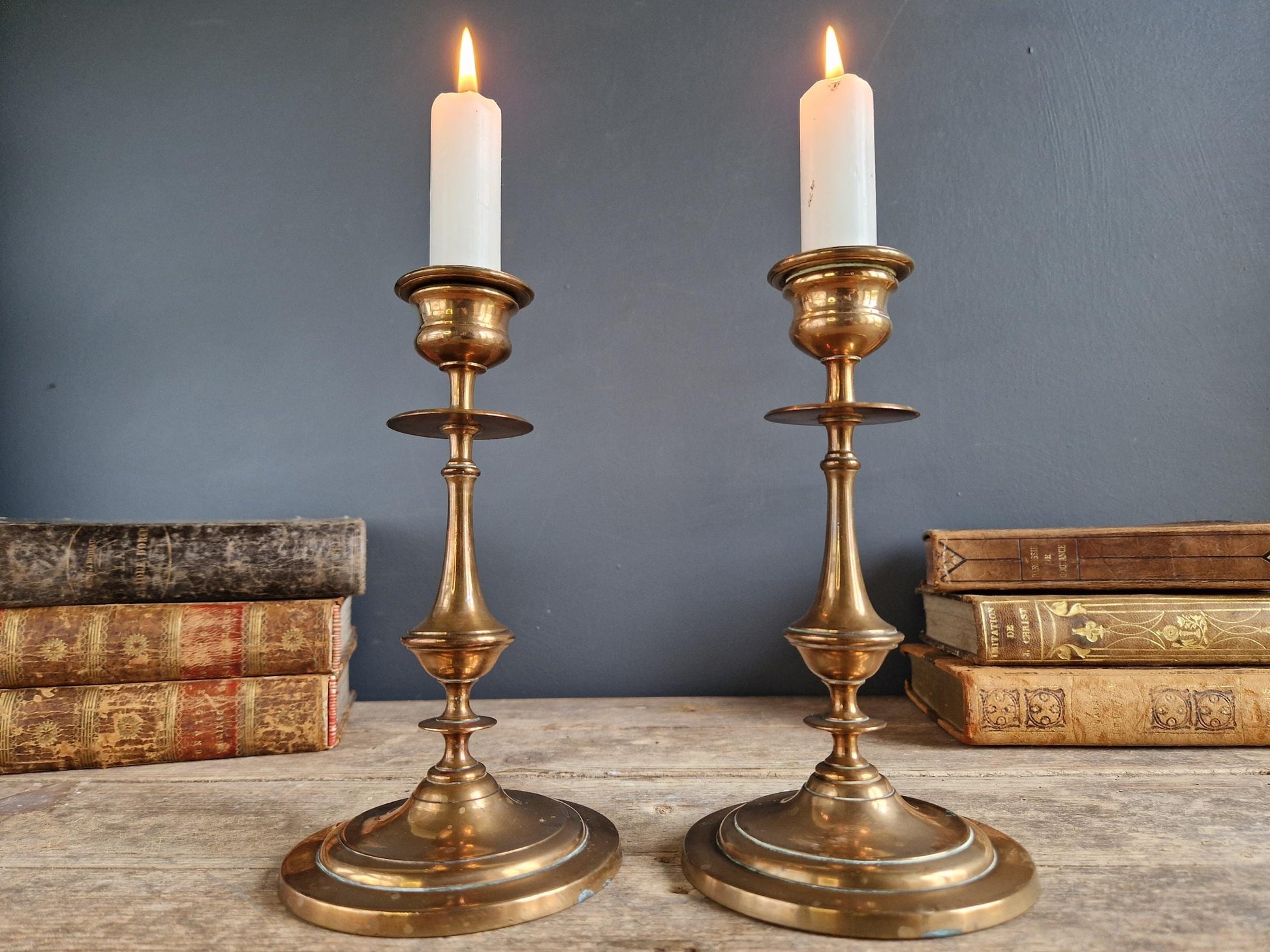 Pair of brass antique candle holders with candles.