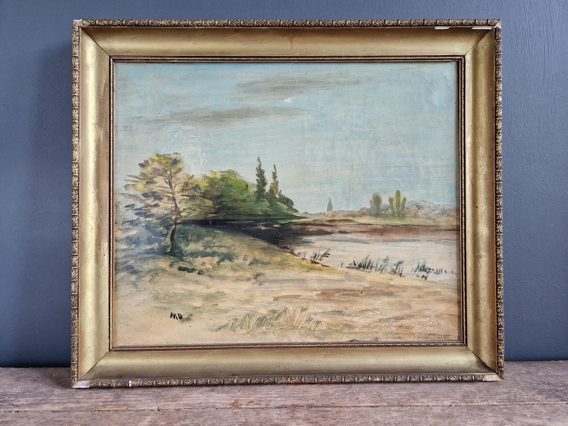 French oil painting of a lake side scene. Gilt frame. Soft muted pastel colours.