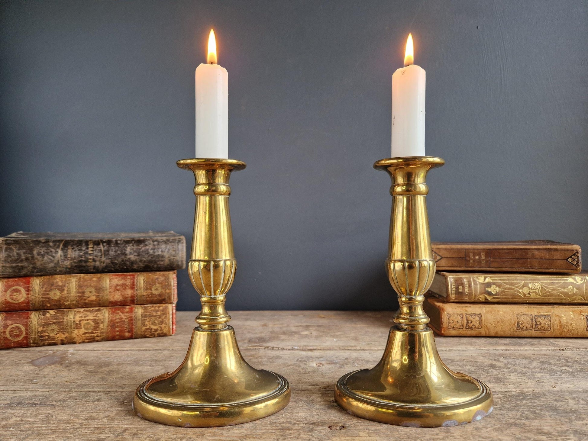 Pair of French antique brass candlesticks with candles.