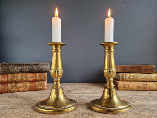Pair of French antique brass candlesticks with candles.
